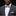 Man wearing a gray suit with a patterned bow tie and pocket square on a black background
