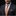 Man wearing a dark suit with an orange patterned tie and matching pocket square on a black background