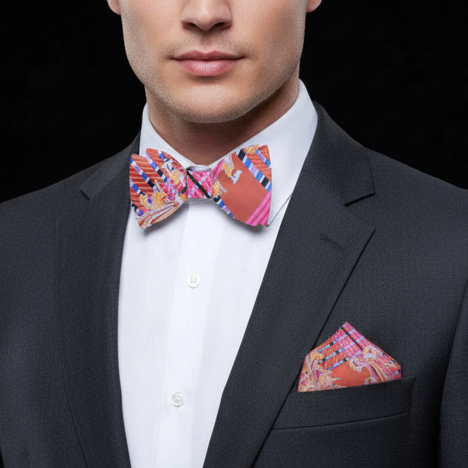 Man wearing a colorful bow tie and matching pocket square with a black suit.