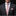 Man wearing a black suit with a patterned tie and pocket square on a dark background