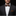 Man wearing a black suit with a patterned bow tie and pocket square on a dark background