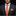 Man wearing a black suit with an orange tie and floral pocket square on a dark background