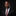 Man wearing a black suit with a colorful tie against a black background