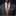 Man wearing a gray suit with a patterned red tie and pocket square on a black background