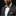 Man wearing a dark suit with a patterned bow tie and pocket square on a black background