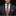 Man wearing a black suit with an orange paisley tie and pocket square against a dark background