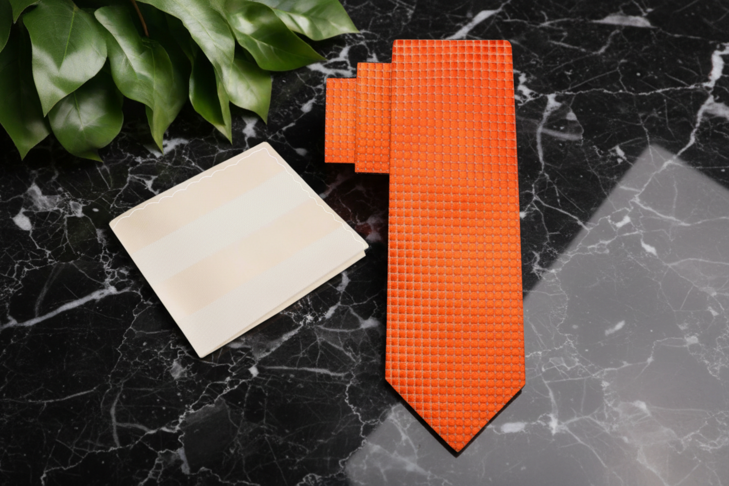 Orange textured tie and beige pocket square on a white background
