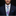 Man wearing a navy suit with a colorful striped tie and pocket square on a black background