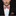 Man wearing a black suit with a patterned bow tie and pocket square on a dark background