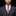 Man wearing a gray suit with a colorful tie and blue pocket square on a black background