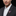 Man wearing a suit with a decorative rooster pin on a black background
