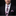 Man wearing a black suit with a pink and black floral tie and pocket square on a black background