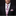 Man wearing a black suit with a pink floral tie and pocket square on a dark background