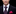 Man wearing a dark suit with a patterned tie and pink pocket square on a black background