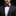 Man wearing a black suit with a white shirt and burgundy bow tie and pocket square on a dark background