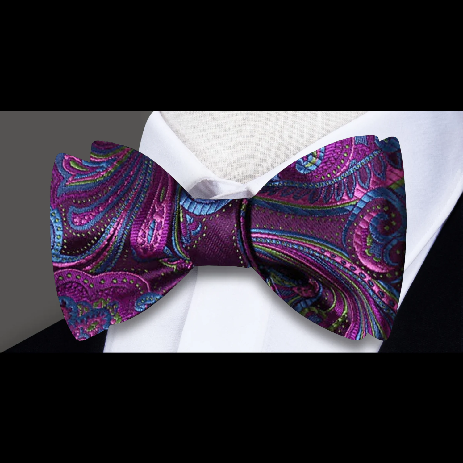 A matching set of self-tie bow tie and pocket square with a swirling paisley design in purple and blue shades on a white background.