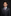 Young boy in a formal suit with a purple tie against a black background