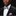 Man wearing a black suit with a colorful bow tie and pocket square against a dark background