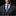 Man wearing a dark gray suit with a purple plaid tie and pocket square on a black background