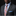 Man wearing a dark suit with a colorful tie and light blue shirt against a black background