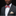 Man wearing a gray suit with a colorful bow tie and pocket square on a black background