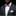 Man wearing a black suit with a colorful bow tie and pocket square on a black background