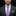 Man wearing a dark suit with a purple tie against a black background