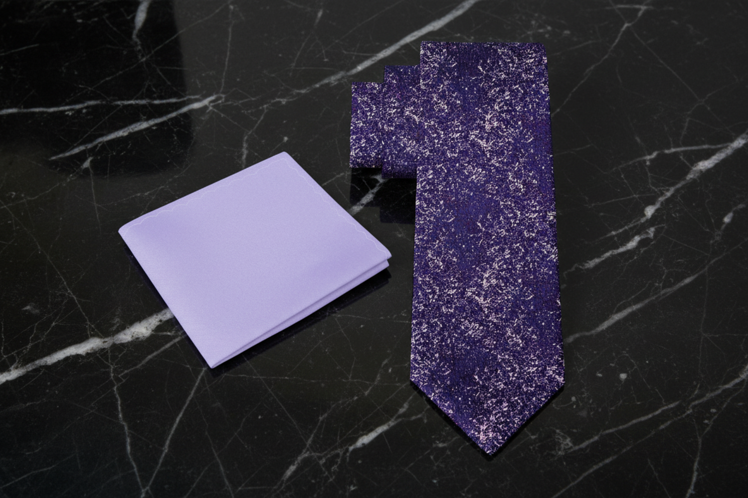 Purple tie and pocket square set on a black marble background