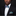 Man wearing a black suit with a colorful bow tie and pocket square against a dark background