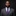 Man wearing a gray suit with a purple tie against a black background
