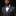 Man wearing a gray suit with a purple bow tie and floral pocket square on a black background