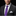 Man wearing a dark suit with a purple tie and white pocket square on a black background