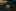 Rainbow-colored circular object on a dark surface