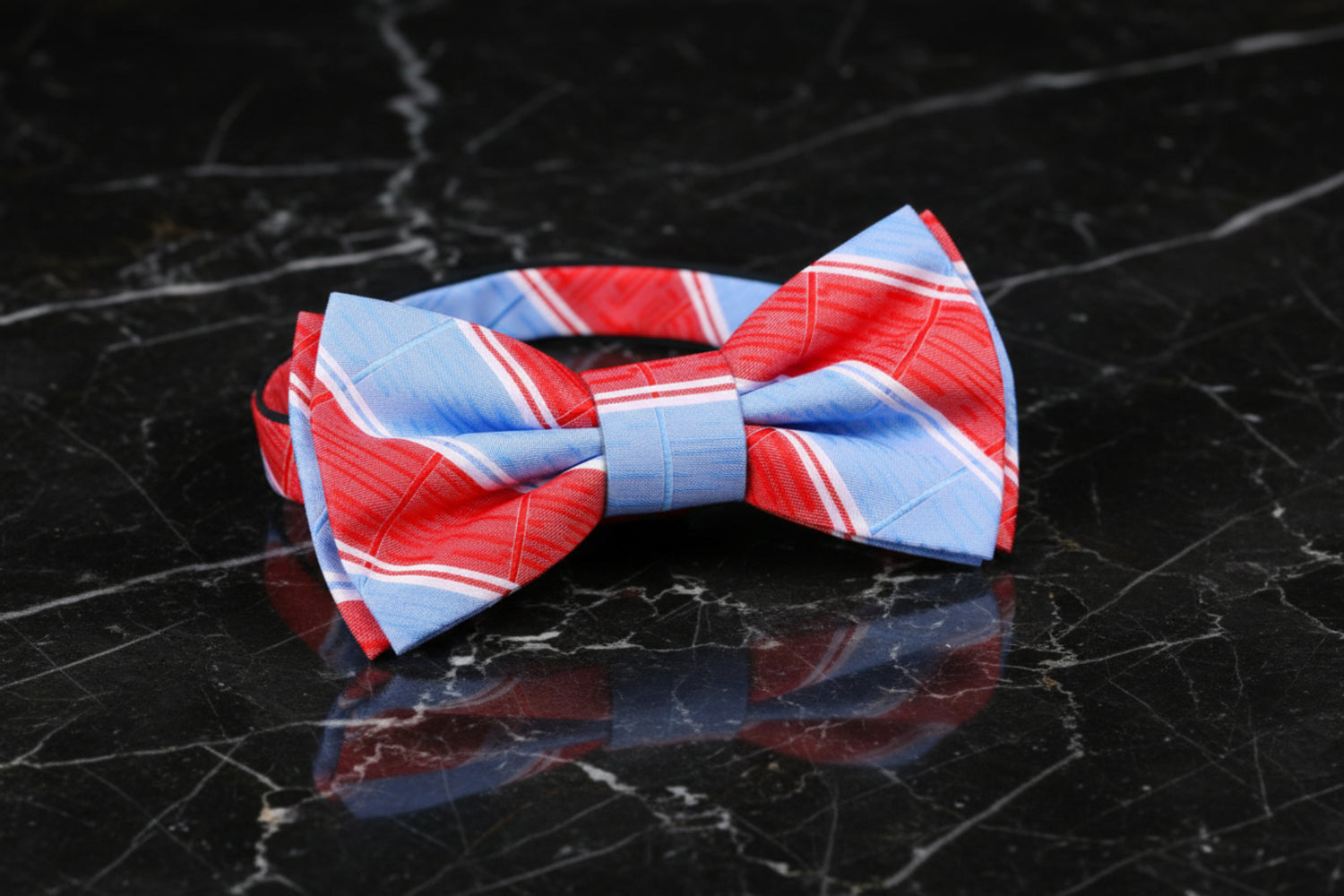 A bow tie with a grey and blue plaid pattern displayed on a dark background