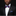 Man wearing a black suit with a colorful bow tie and pocket square on a black background