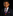 Young boy in a suit with a colorful tie and pocket square on a black background