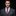 Man wearing a gray suit with a colorful tie and pocket square on a black background