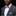 Man wearing a gray suit with a colorful bow tie and blue pocket square on a black background