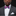 Man wearing a gray suit with a white shirt and colorful bow tie against a black background