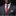 Man wearing a gray suit with a red paisley tie and plaid pocket square on a black background