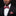 Man wearing a black suit with a red paisley bow tie and pocket square against a black background