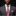 Man wearing a gray suit with a red paisley tie and pocket square on a black background