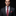 Man wearing a gray suit with a red paisley tie and pocket square on a black background