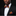 Man wearing a black suit with a colorful striped bow tie and pocket square against a dark background