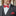 Man wearing a gray suit with a red bow tie and pocket square, blurred background