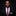 Man wearing a black suit with a red paisley tie and checkered pocket square on a black background