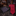 Red patterned tie and pocket square on a dark surface with a background of shelves with ties.