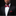 Man wearing a black suit with a red bow tie and pocket square on a dark background