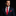 Man wearing a navy suit with a red polka dot tie and pocket square on a black background