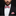 Man wearing a black suit with a red and white checkered bow tie and pocket square on a dark background